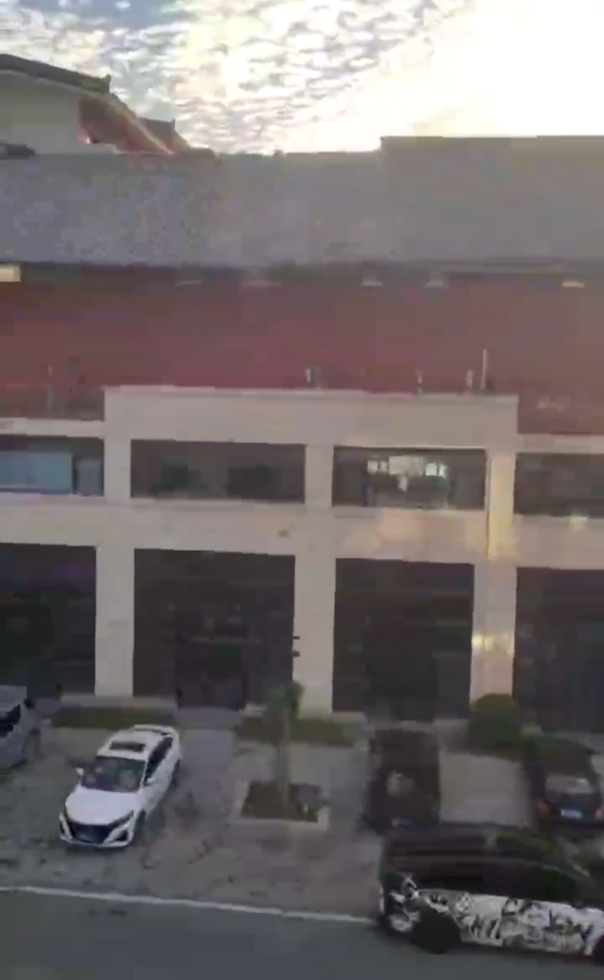 Roof Rools Down Front Of Building Like Giant Window Blind Before Crashing Into Cars Below