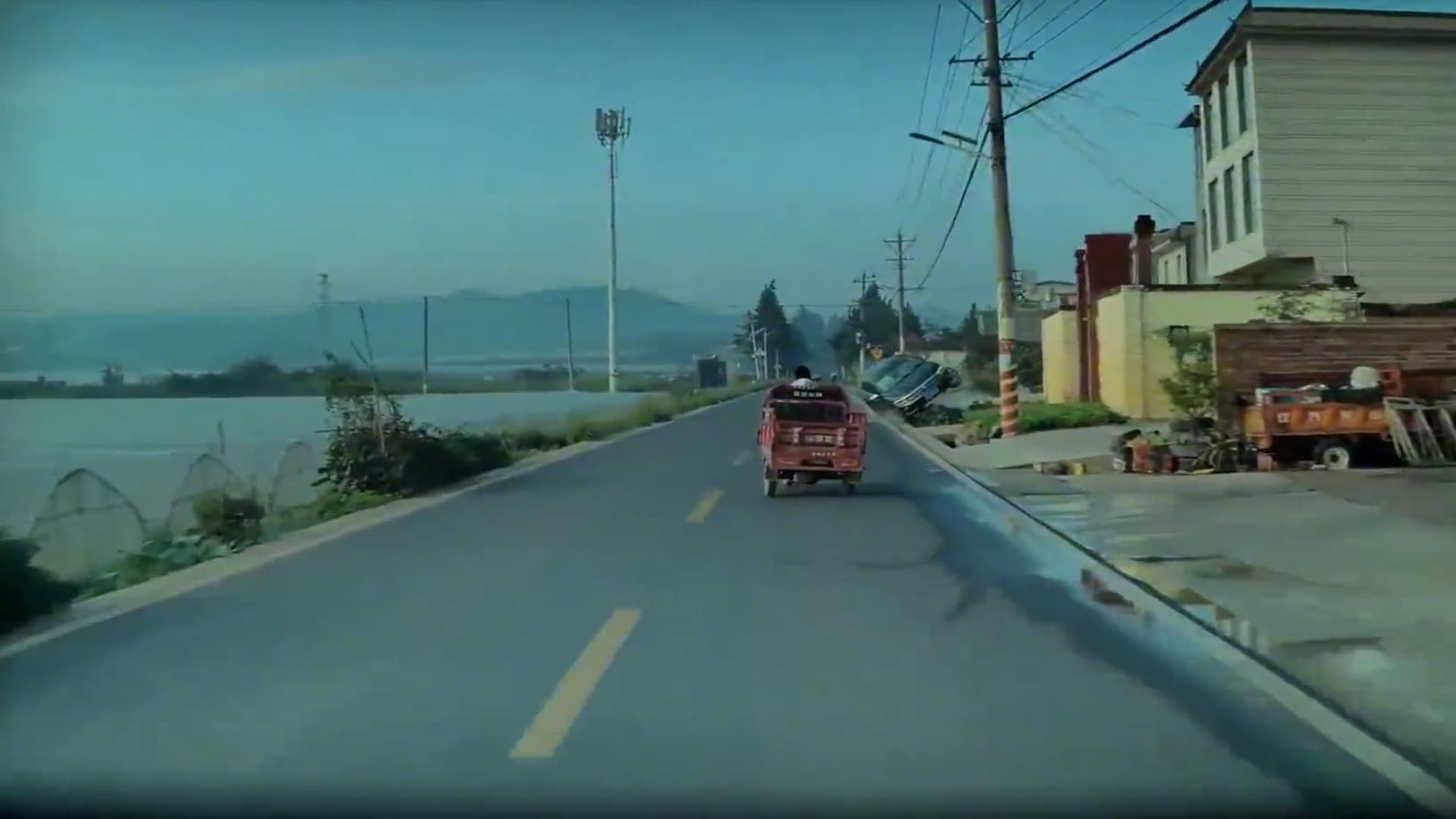 Car goes off road into a ditch in Yunnan, China. It got  caught on wall and no one was harmed.  Note: Photo is a screenshot from a video. (AsiaWire/NX)