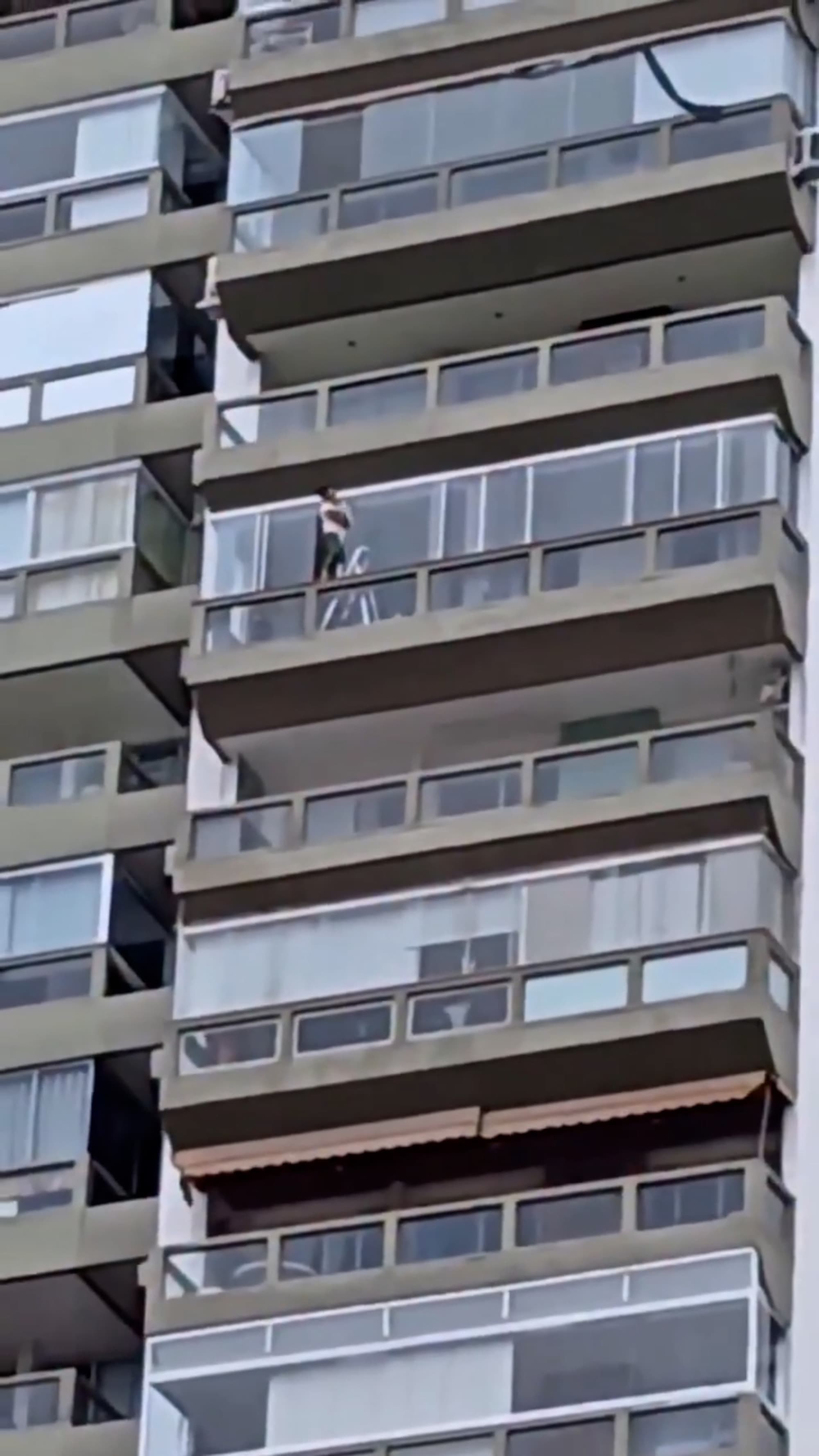 Terrifying Moment Woman Balances On Ladder While Cleaning High-Rise Apartment Windows