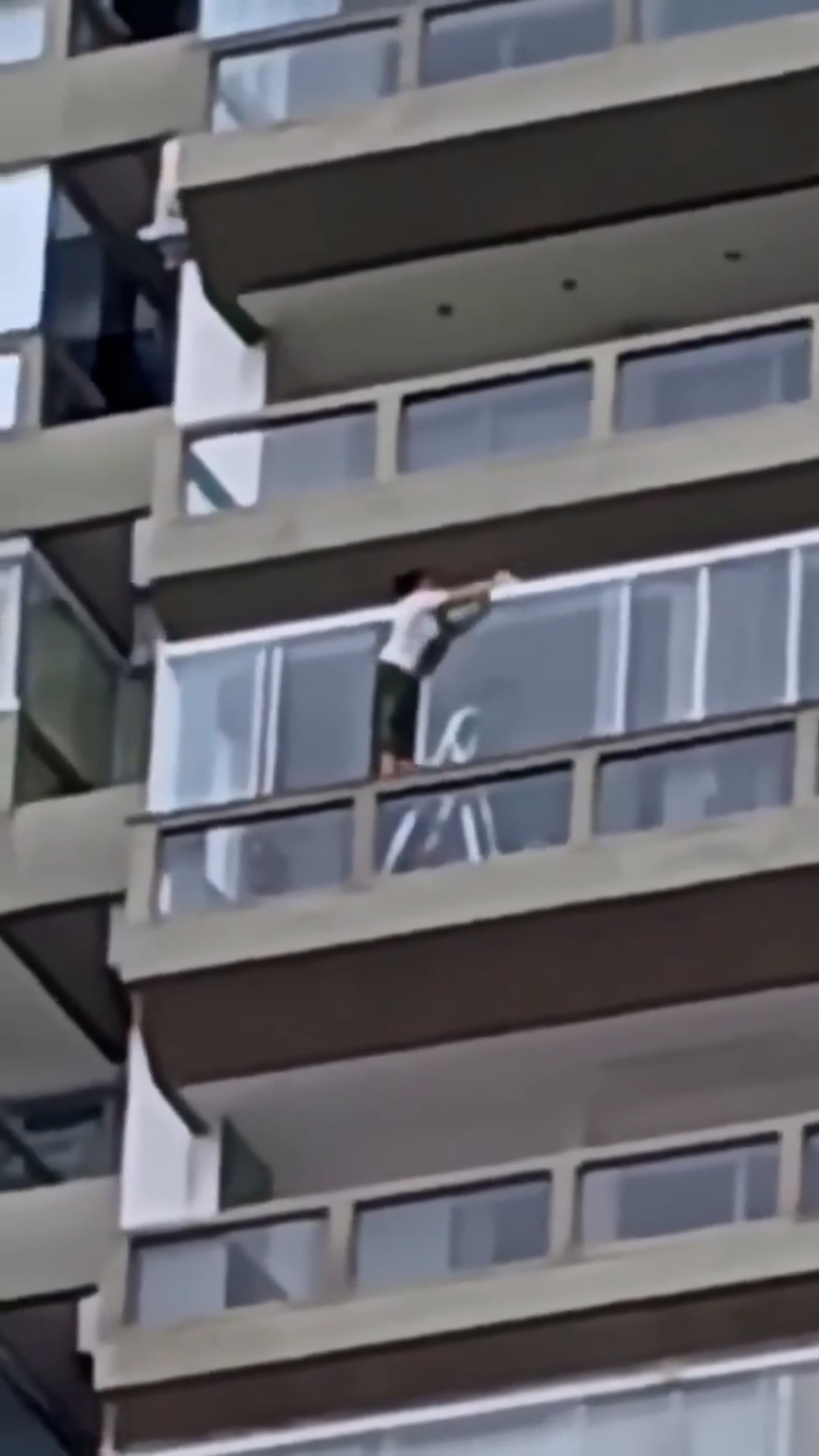 Woman cleans apartment windows on high floor in Barra da Tijuca, Rio in Brazil, undated. Note: Photo is a screenshot from a video. (Newsflash/NX)